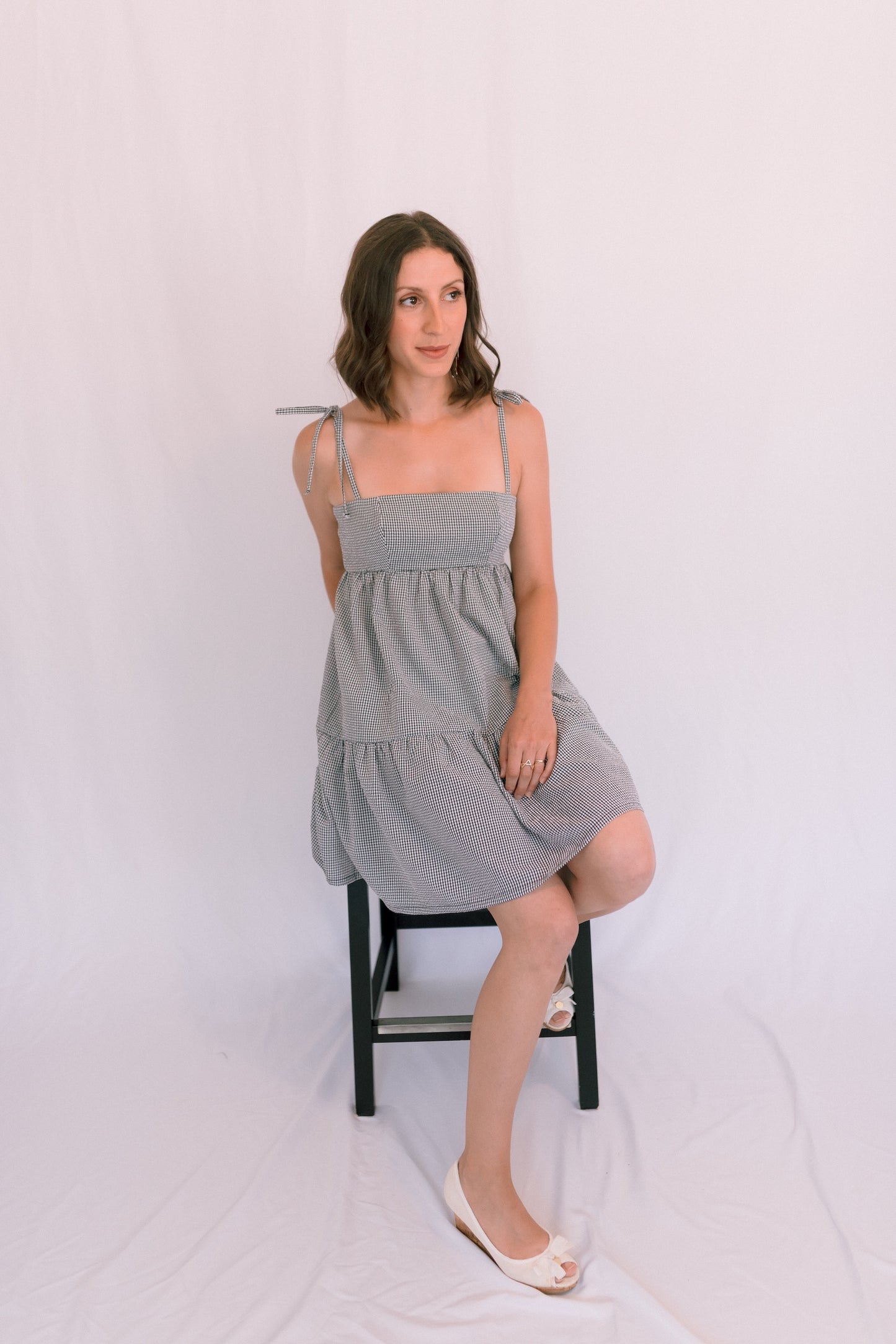 Ethical and sustainable clothing made in Canada - Pros and Cons Apparel.  Tie up gingham mini dress; tiered gathered skirt, Above knee sundress